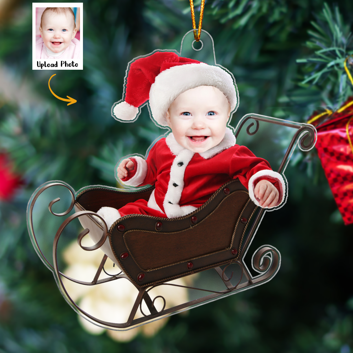 Personalized baby photo ornament featuring a baby in Santa outfit sitting in a sleigh with Christmas tree background
