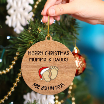 Personalized Christmas ornament for parents with wooden round design and baby footprints hanging on tree