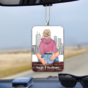 Personalized couple car hanger featuring a custom illustration of a couple with city skyline background hanging from rearview mirror
