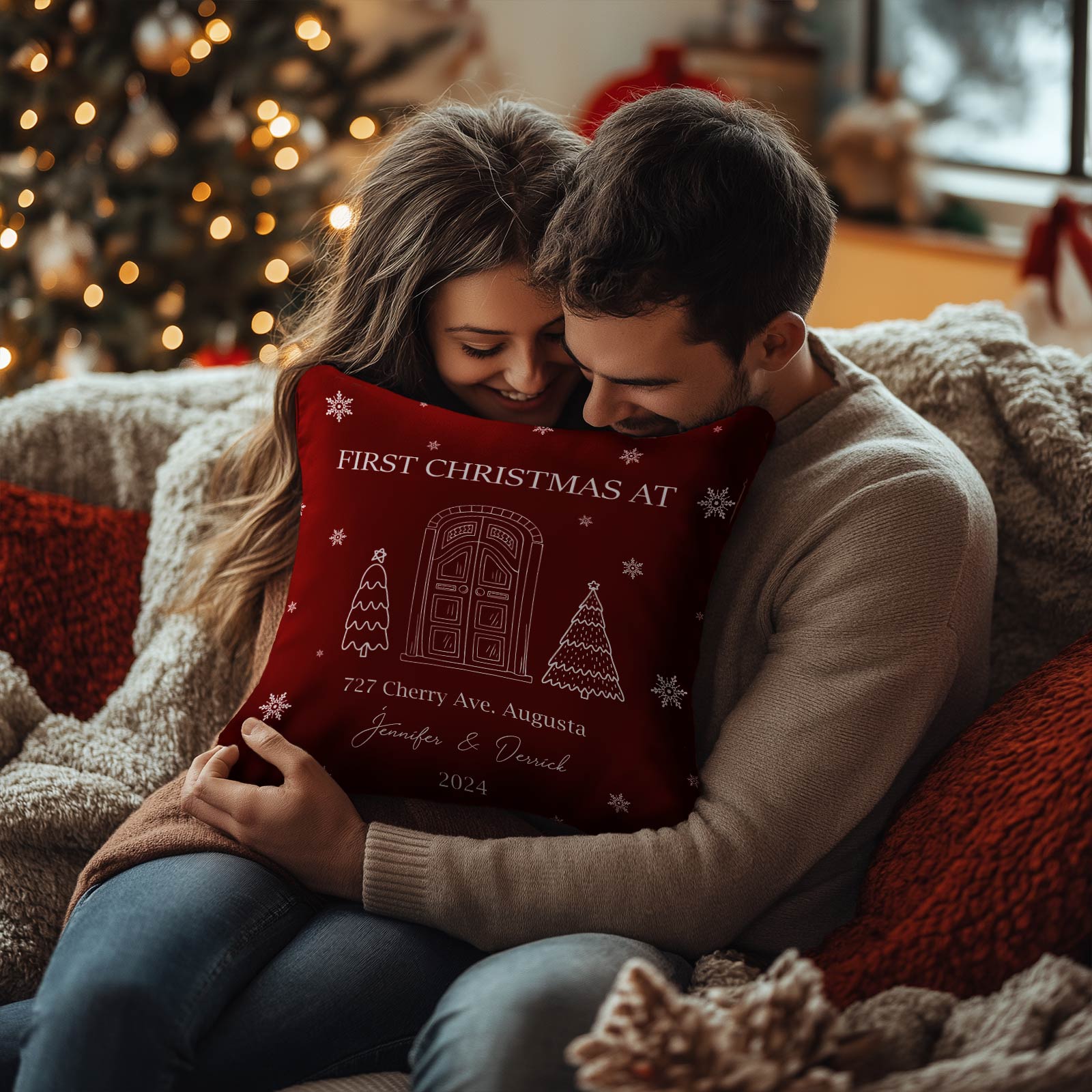 Couple cozying on couch holding personalized couple Christmas pillow with festive door design