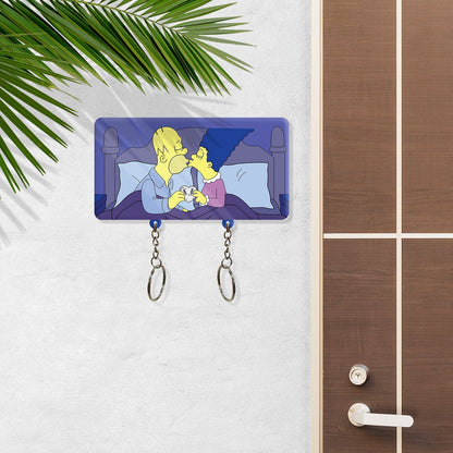 Personalized couple keychain holder featuring cartoon couple kissing on bed with two key rings