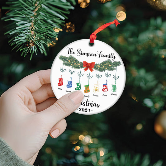Personalized family Christmas ornament with names and colorful stockings hanging from pine branches