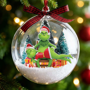 Personalized Grinch couple ornament inside a festive glass ball with holiday decorations