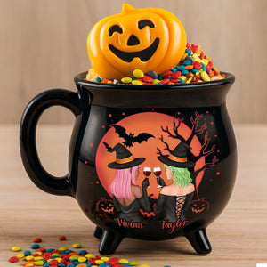 Personalized Halloween cauldron mug featuring two witches with colorful toppings and Halloween decorations