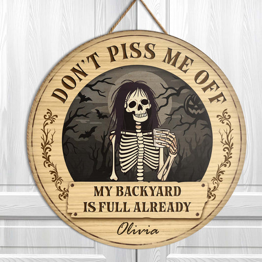 Personalized Halloween wooden door sign featuring a skeleton with a humorous phrase and spooky background