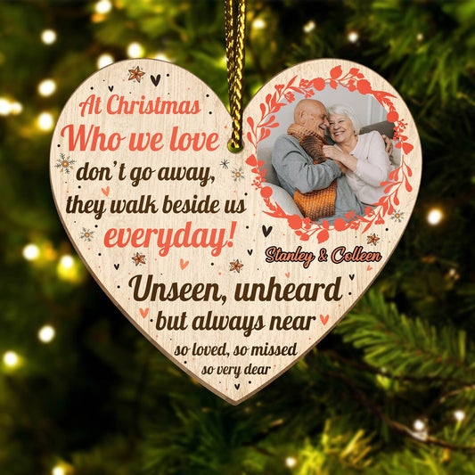 Heart-shaped personalized memorial Christmas ornament with photo and sentimental message hanging on tree