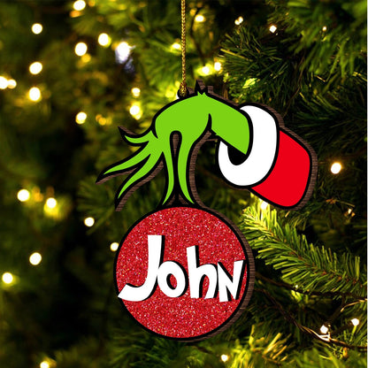 Personalized monster family Christmas ornament with green monster hand and red glitter ball named John hanging on tree
