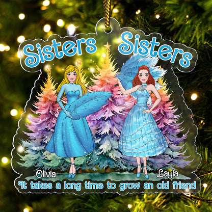 Personalized sisters Christmas ornament with two sisters in blue dresses and colorful trees background
