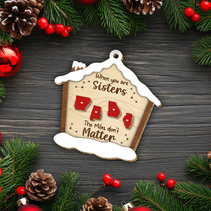 Personalized Christmas ornament with sisters theme featuring state shapes and snow-covered house design