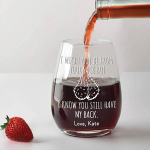 Personalized stepdad wine glass with humorous message being filled with red wine next to a strawberry