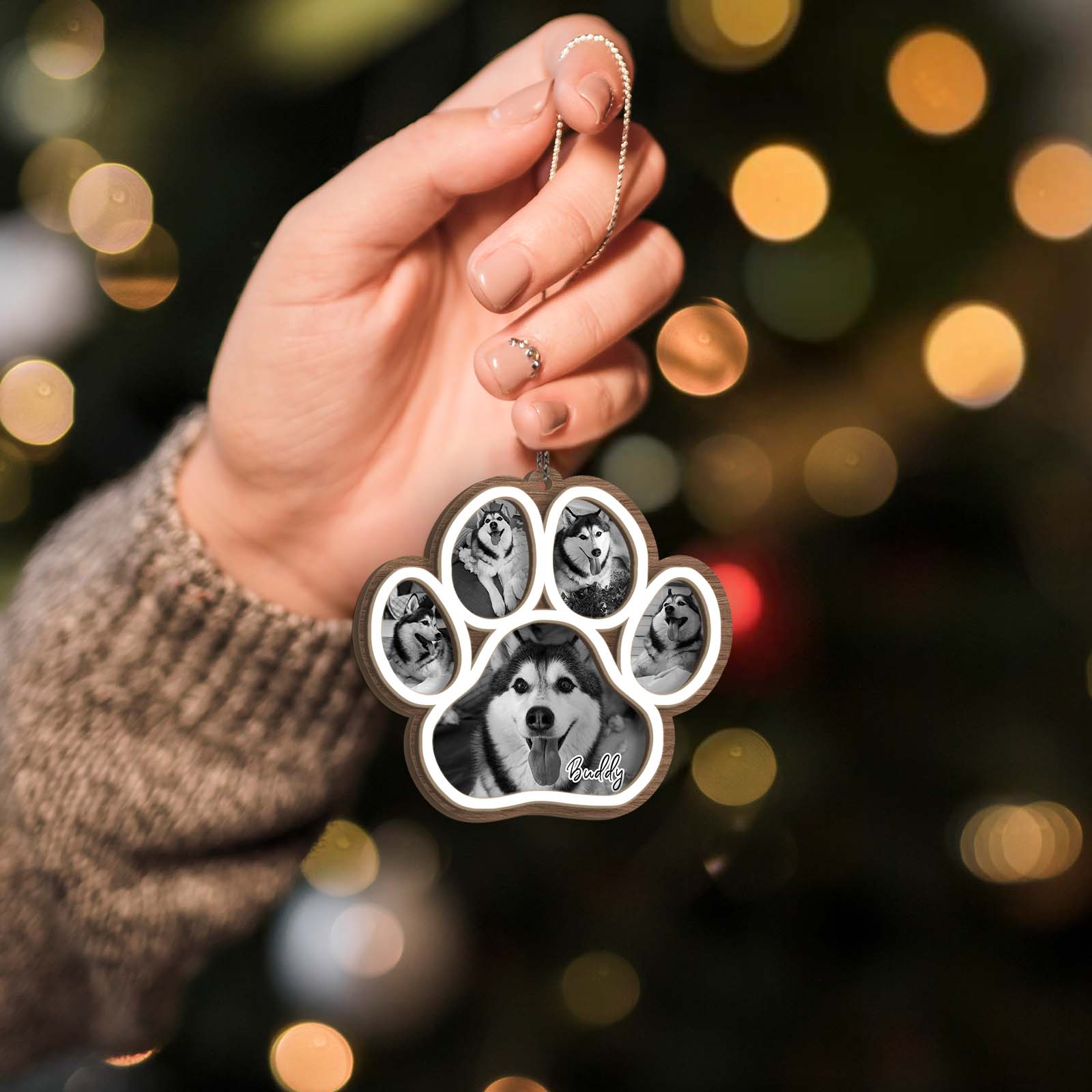 Hand holding a personalized dog memorial ornament paw shaped photo charm featuring a husky and multiple images