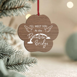 Wooden paw shaped personalized dog memorial ornament engraved with Rainbow Bridge text wings clouds and red ribbon