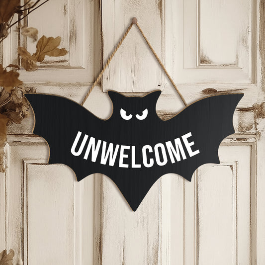 funny Halloween door sign black bat shaped wooden hanger with UNWELCOME text and angry eyes on white door