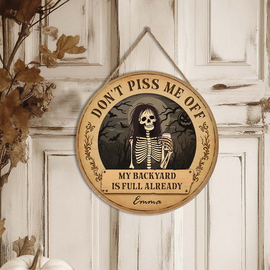 Round personalized Halloween wooden door sign with skeleton and text Dont Piss Me Off My Backyard Is Full Already