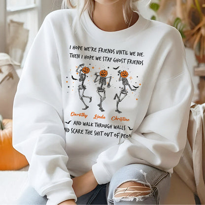 Woman wearing a white custom best friend Halloween sweatshirt showing three dancing skeletons with pumpkin heads and names