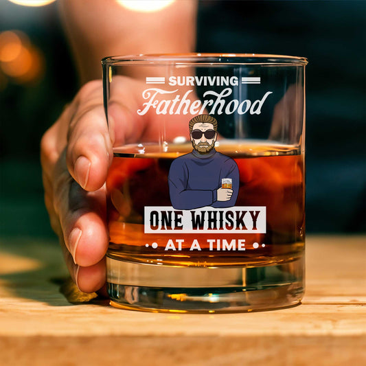 Personalized Whiskey Glass showing held rocks glass with whiskey and fatherhood design One Whisky At A Time