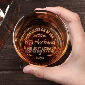 Personalized Whiskey Glass engraved with Congrats on being my husband message held in hand over wood table